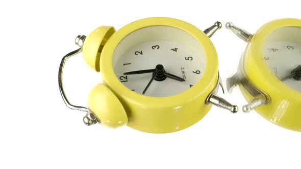 Vertical Video Small Yellow Vintage Alarm Clock Rotating Isolated on White Background