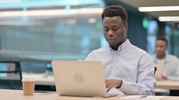 African Businessman with Laptop Having Headache