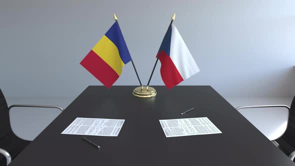 Flags of Romania and the Czech Republic and Papers on the Table