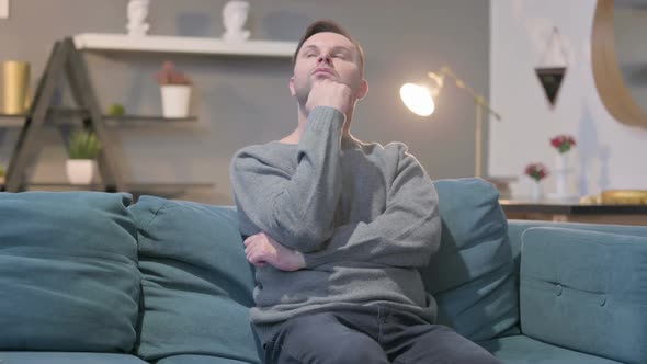 Casual Man Thinking While Sitting on Sofa