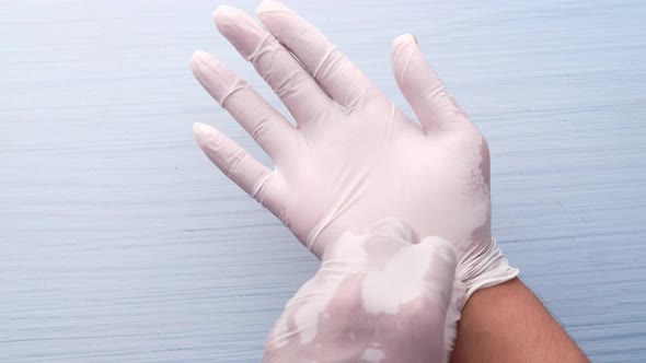 Doctor Hand with Glove on Wooden Background.