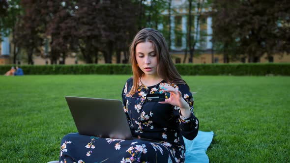 A Girl with a Laptop and a Credit Card Outdoors