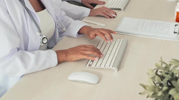 Female Doctor Working on Computer at Desk