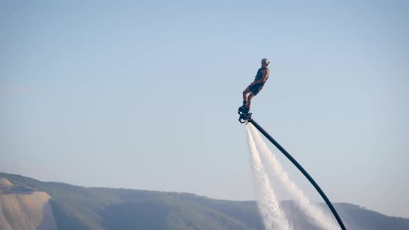 Extreme Athlete Is Using Flyboard on Sea, Moving Legs and Torso To Control Movements in Summer Day