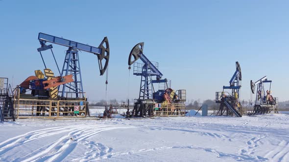 Oil and gas industry, Working oil pump jack on a oil field at winter sunny day