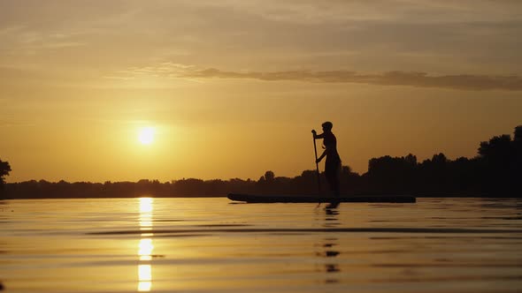 Woman Paddling on SUP Board in Slow Motion