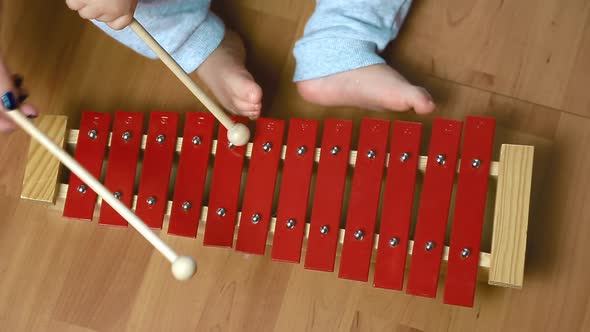 The Child Plays with Sticks on the Red Xylophone, Percussion Instrument, Top View