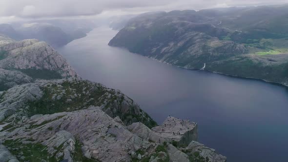 Aerial Slomo Drone shot of Preikestolen, Norway, with Tourists Walking and Photographing.