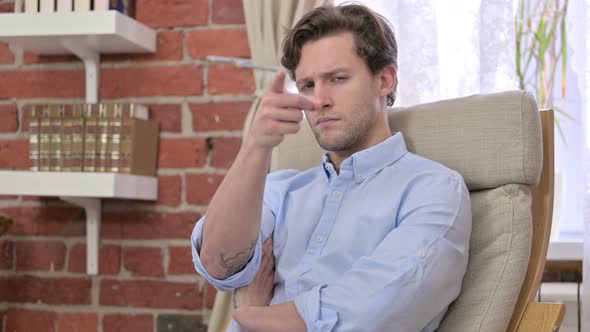 Focused Young Man Pointing Finger at Camera