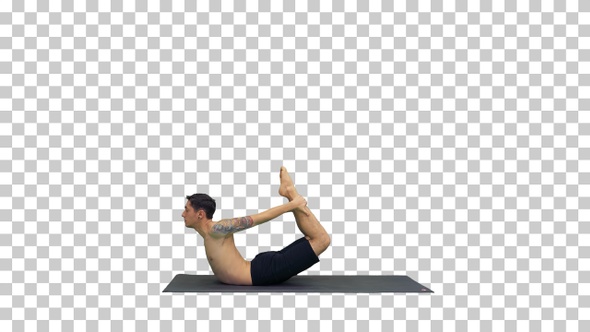 Sporty muscular young yogi man doing backbend exercise