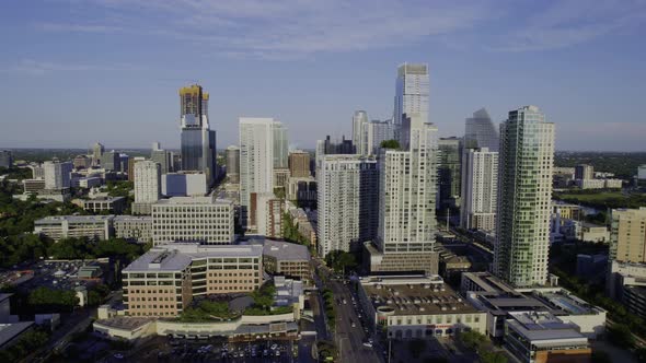 Aerial view away from the sunny Austin skyline, daytime in Texas, USA - pull back, drone shot