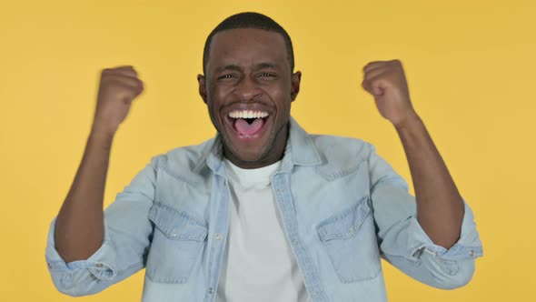 Excited Young African Man Celebrating, Yellow Background 