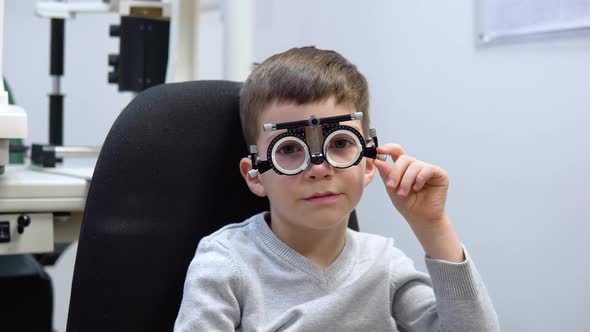 A Caucasian Boy in a Trial Frame for the Selection of Contact Lenses at an Appointment with an