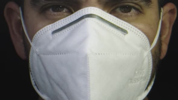 Close-up of Man As He Puts His Protective Face Mask on