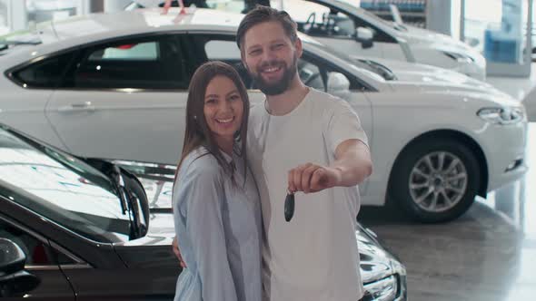The Concept of Buying or Renting a Car, Young Happy Interracial Couple with New Car Keys