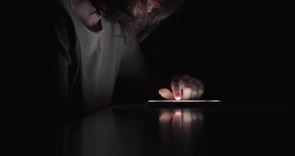 Woman Is Using Swiping Phone In Complete Dark. Loneliness. Loneliness