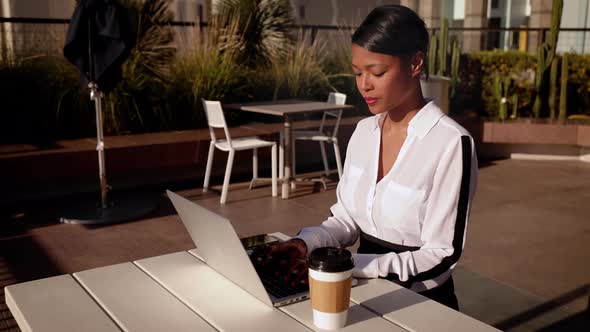 Mixed ethnicity business woman works on her laptop