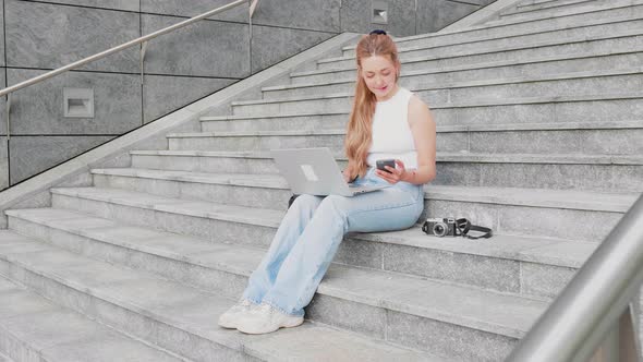 Young woman flexible worker outdoor using computer and smartphone