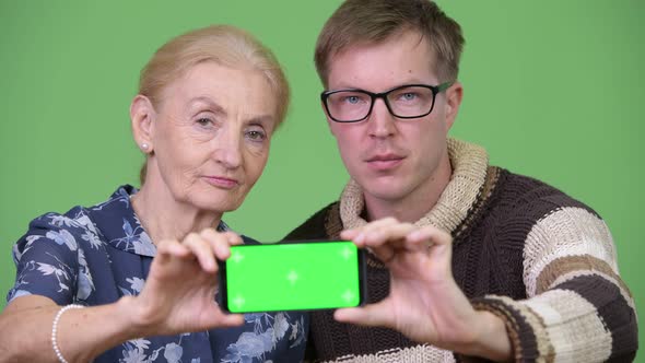 Happy Grandmother and Grandson Showing Phone Together