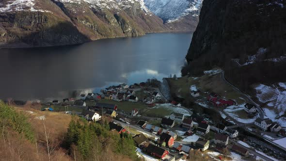 Undredal village along Aurlandsfjord in Norway - Forwarding aerial from hillside with slow tilt up f