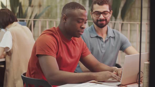 Joyous Diverse Men Working Together in Coworking Office