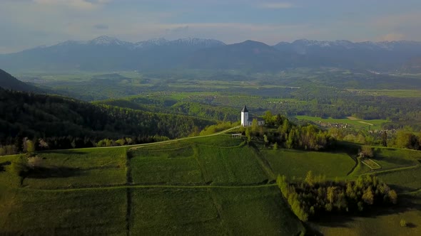 drone footage sunset at Church of St. Primus and Felician, Jamnik, Slovenia 