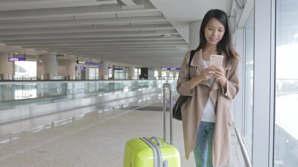 Woman using mobile phone in Hong Kong international airport