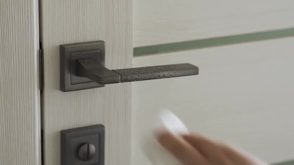 Woman Disinfects Doorknob