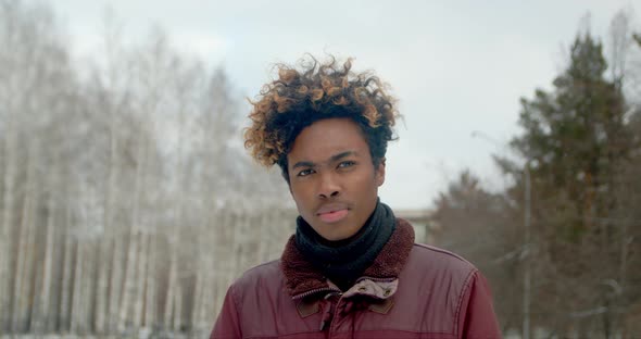 Angry Black Guy Portrait Close Up African Man Looking at Camera in Winter .