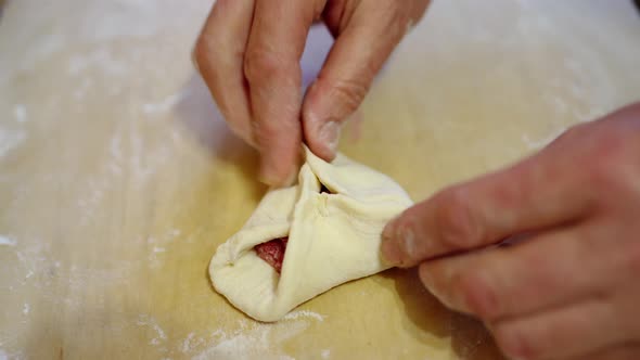 Female Hands are Molding the Dough of a Pie with Meat Filling