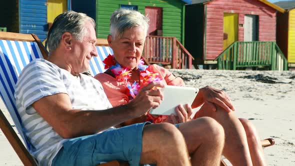 Senior couple interacting with each other while using digital tablet