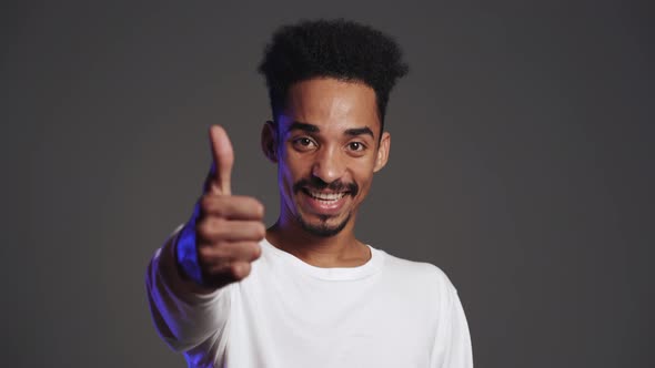 Young African Handsome Man Making Thumbs Up Sign Over Grey Background