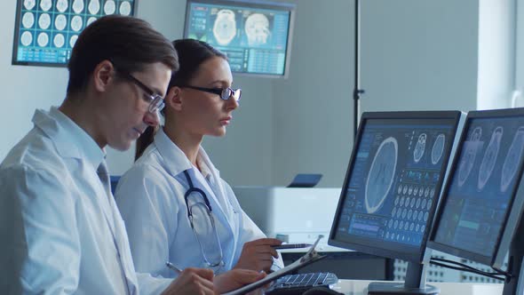 Professional medical doctors working in hospital office making computer research.