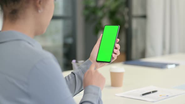 Rear View of African Woman Using Smartphone with Green Chroma Screen