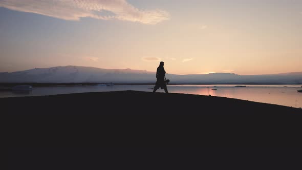 Silhouette Of Man Walking Through Icelandic Landscape