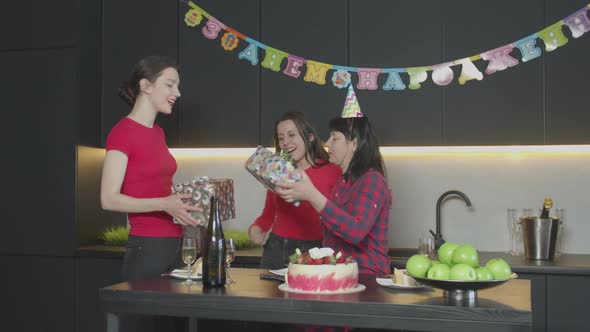 Daughters Giving Birthday Gifts To Happy Mother