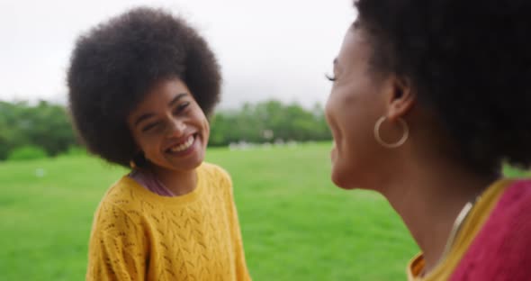 Two mixed race women laughing in park