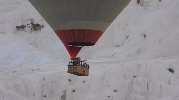 Hot Air Balloons in White Travertines of Pamukkale, a Touristic Natural World Heritage Site