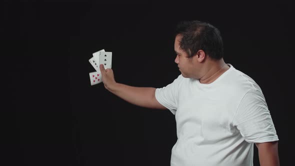 Asian Magician Shows Trick With Playing Cards. Manipulation With Props. Sleight Of Hand