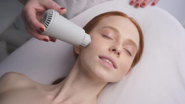 Beautiful Woman at a Cosmetologist's Reception Receives a Vacuum Massage of the Skin of the Face