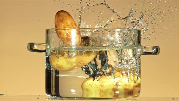 Fresh Potatoes Fall Into a Pot of Water with Splashes