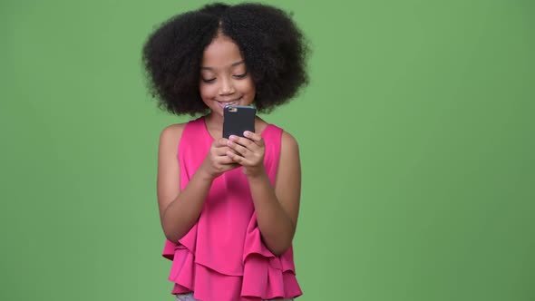 Young Cute African Girl with Afro Hair Using Phone