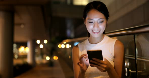 Woman using mobile phone in city 