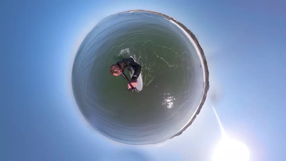 Little tiny planet 360 small world view of a man sup stand-up paddleboard surfing.