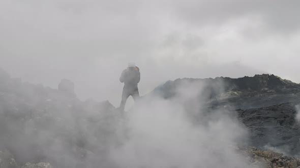 Photographer Amongst Thick Smoke On Rocks Of Lava Field