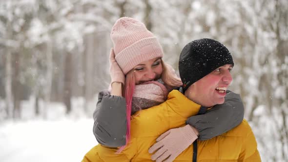 Happy Loving Couple Walking in Snowy Winter Forest, Spending Christmas Vacation Together. Outdoor