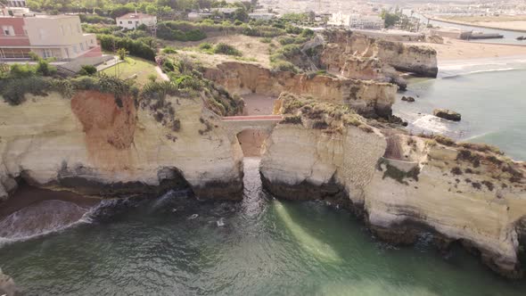 Aerial pullback over Arch bridge at Praia dos Estudantes (Students Beach) in Lagos, Algarve