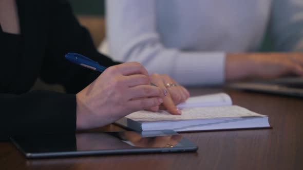 Girl Writes Information in a Notebook During Negotiations