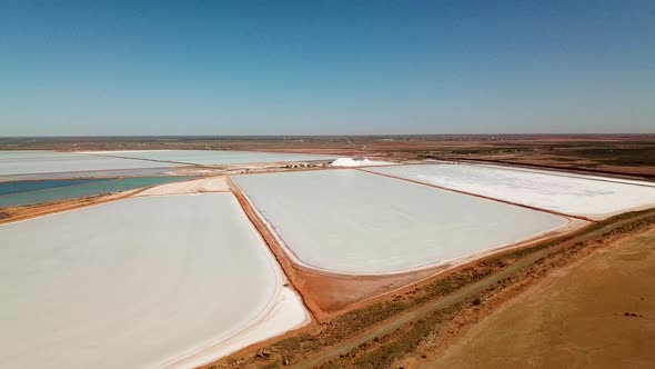 Aerial footage large Australian salt mine, arid landscape, drone circles right-left