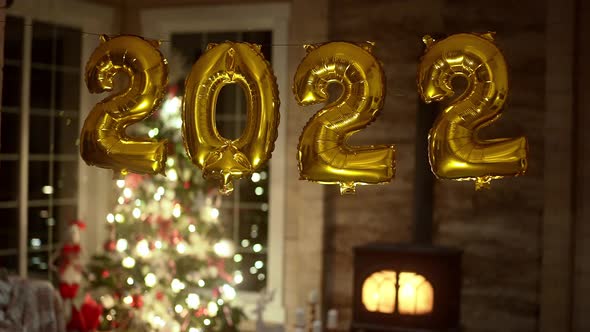 Golden New Year Party Balloons of Year 2022 in Front of the Festive Background